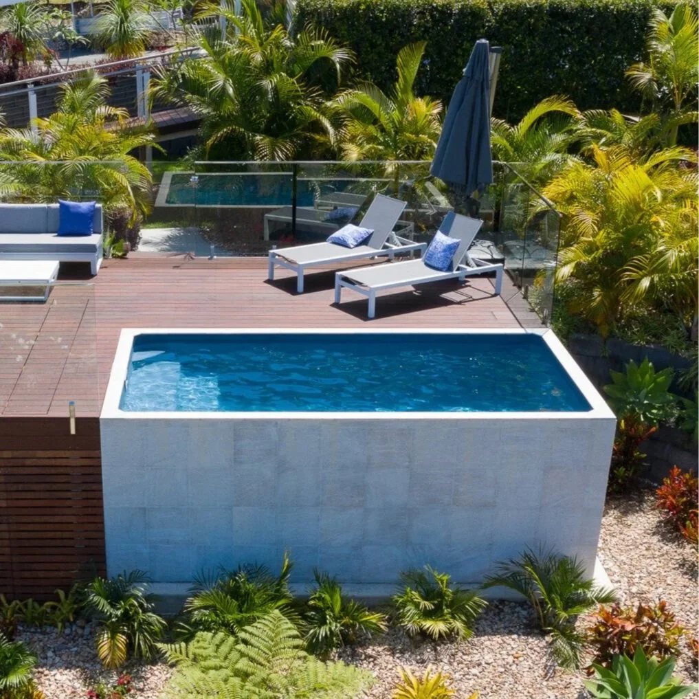 Above ground concrete plunge pool on a timber deck with sun lounges