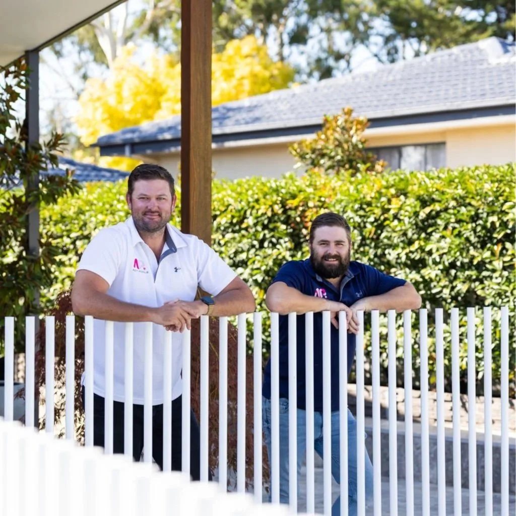 Two ACT Pools builders standing at a pool fence